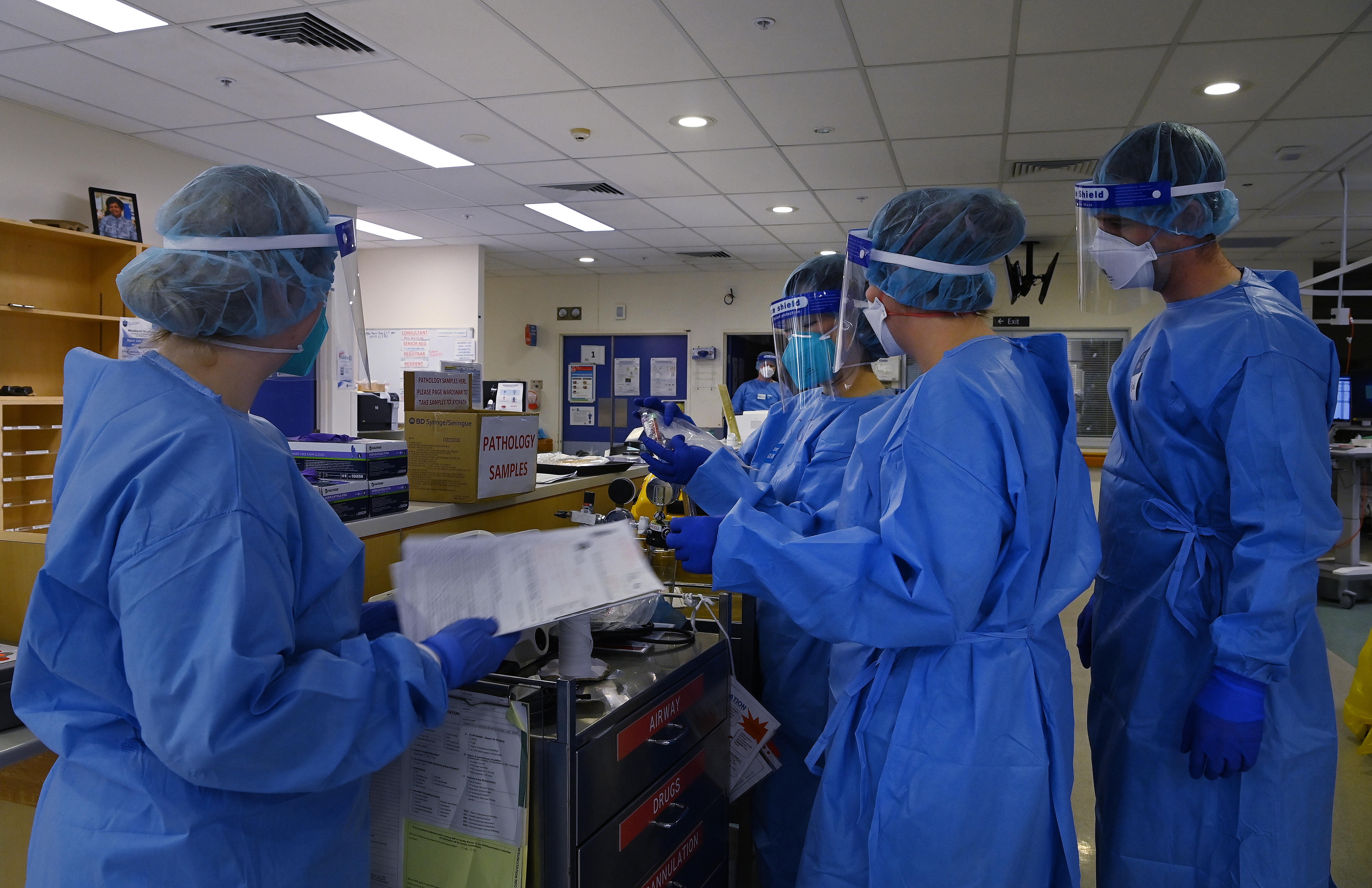 Several people dressed in PPE speaking.
